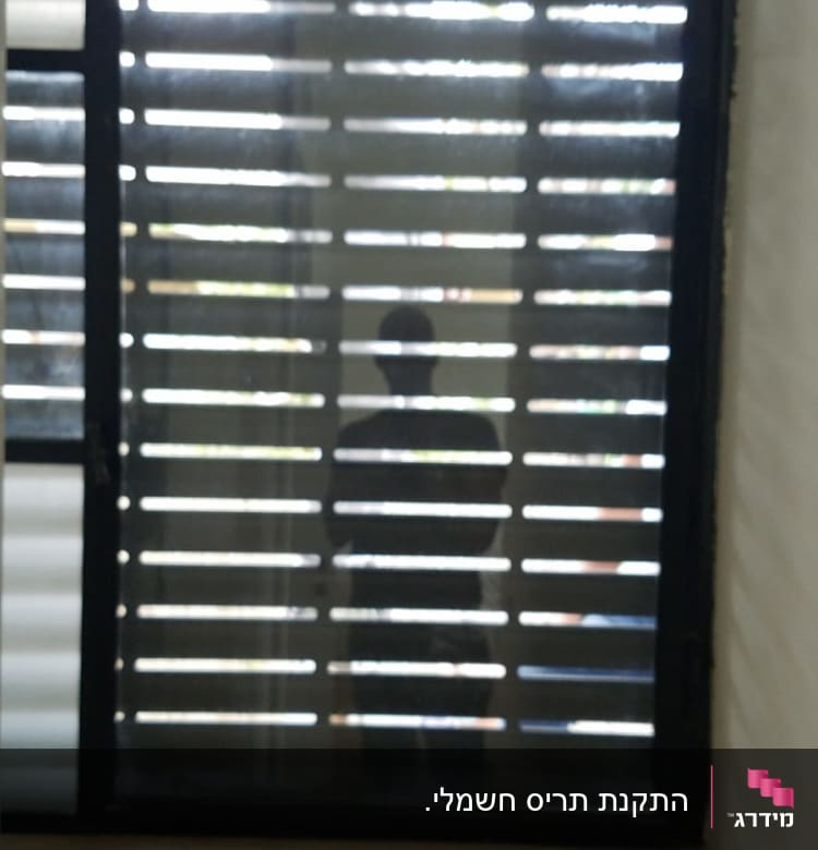 תריסי אלומיניום בחלון עם אור שמש
